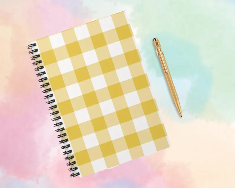 A yellow buffalo plaid spiral notebook with a warm check pattern adding cozy texture